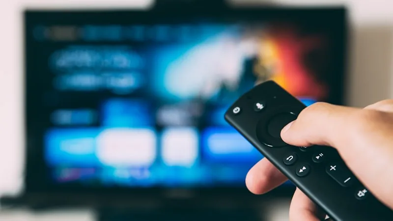 Television remote pointed at a screen showing a streaming app interface